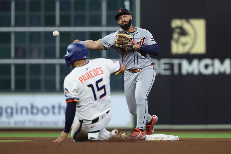Apr 28, 2025; Houston, Texas, USA; Houston Astros third baseman Isaac Paredes (15) is out as Detroit Tigers center fielder Javier Baez (28) throws to first base to complete a double play during the sixth inning at Daikin Park. Mandatory Credit: Troy Taormina-Imagn Images