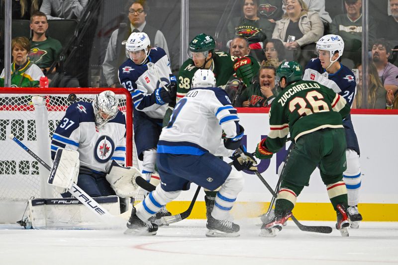 Sep 27, 2024; Saint Paul, Minnesota, USA;  Winnipeg Jets goalie Connor Hellebuyck (37) makes a save on Minnesota Wild forward Mats Zuccarello (36) during the first period at Xcel Energy Center. Mandatory Credit: Nick Wosika-Imagn Images

