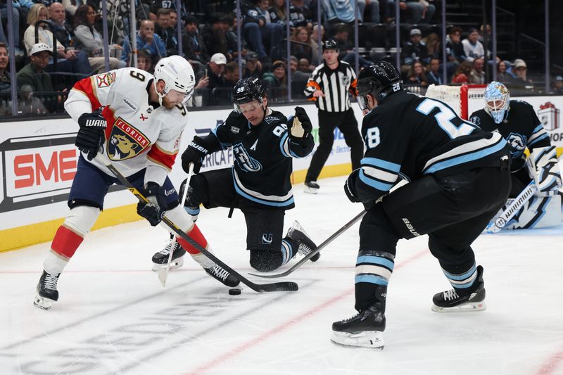 Dec 10, 2025; Salt Lake City, Utah, USA; Florida Panthers center Sam Bennett (9) battles for a puck against Utah Mammoth defenseman Mikhail Sergachev (98) and defenseman Ian Cole (28) during the third period at Delta Center. Mandatory Credit: Rob Gray-Imagn Images