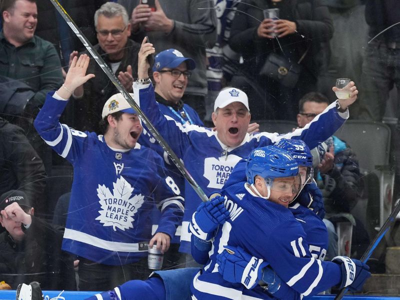 Mar 26, 2024; Toronto, Ontario, CAN; Toronto Maple Leafs left wing Tyler Bertuzzi (59) scores a goal and celebrates with Toronto Maple Leafs center Max Domi (11) against the New Jersey Devils during the first period at Scotiabank Arena. Mandatory Credit: Nick Turchiaro-USA TODAY Sports