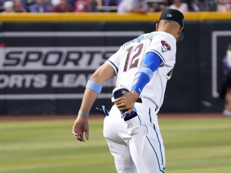 Jun 18, 2023; Phoenix, Arizona, USA; Arizona Diamondbacks left fielder Lourdes Gurriel Jr. (12) stretches amidst his children prior to facing the Cleveland Guardians at Chase Field. Mandatory Credit: Joe Camporeale-USA TODAY Sports