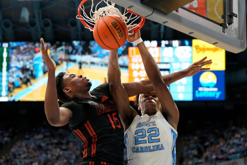 Mar 1, 2025; Chapel Hill, North Carolina, USA;  North Carolina Tar Heels forward Ven-Allen Lubin (22) scores as Miami (Fl) Hurricanes forward Kiree Huie (15) defends in the second half at Dean E. Smith Center. Mandatory Credit: Bob Donnan-Imagn Images