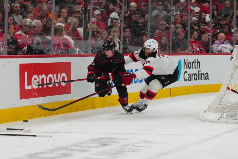Mar 28, 2026; Raleigh, North Carolina, USA;  Carolina Hurricanes right wing Jackson Blake (53) and New Jersey Devils defenseman Dougie Hamilton (7) chase after the puck during the first period at Lenovo Center. Mandatory Credit: James Guillory-Imagn Images