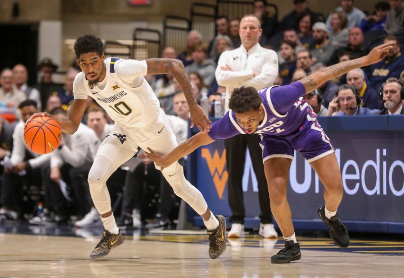 Feb 25, 2025; Morgantown, West Virginia, USA; West Virginia Mountaineers guard Sencire Harris (10) dribbles past TCU Horned Frogs guard Vasean Allette (3) during the first half at WVU Coliseum. Mandatory Credit: Ben Queen-Imagn Images