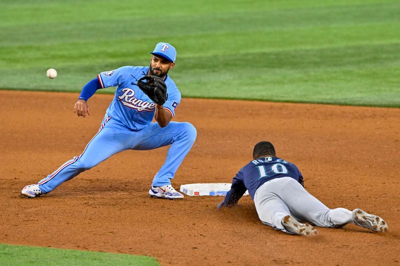 Sep 22, 2024; Arlington, Texas, USA; Seattle Mariners right fielder Victor Robles (10) slides under the tag of Texas Rangers second baseman Marcus Semien (2) during the sixth inning at Globe Life Field. Mandatory Credit: Jerome Miron-Imagn Images