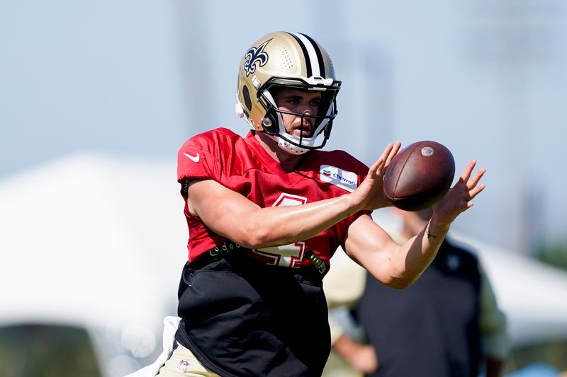 New Orleans Saints quarterback Derek Carr takes a snap during a joint NFL football practice with the Los Angeles Chargers, Thursday, Aug. 17, 2023, in Costa Mesa, Calif. (AP Photo/Ryan Sun)