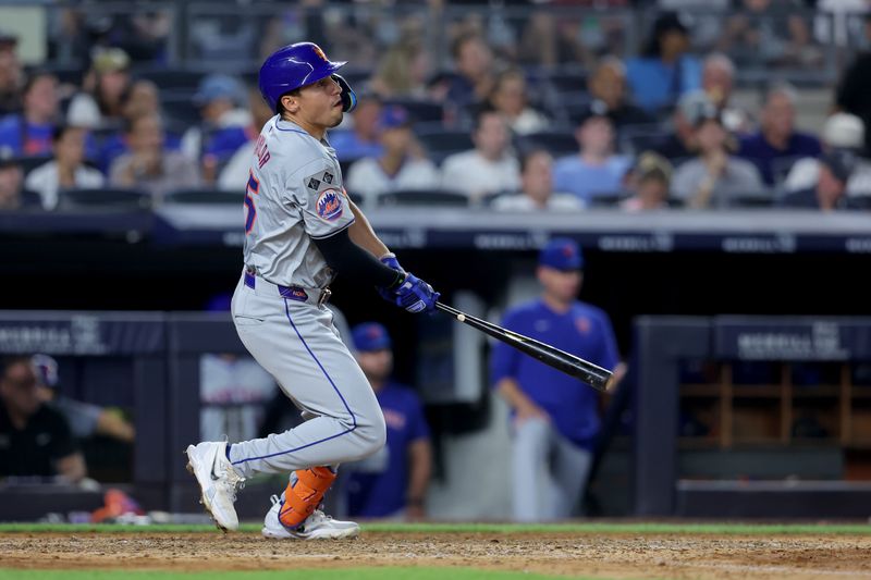 Jul 24, 2024; Bronx, New York, USA; New York Mets center fielder Tyrone Taylor (15) follows through on an RBI single against the New York Yankees during the sixth inning at Yankee Stadium. Mandatory Credit: Brad Penner-USA TODAY Sports