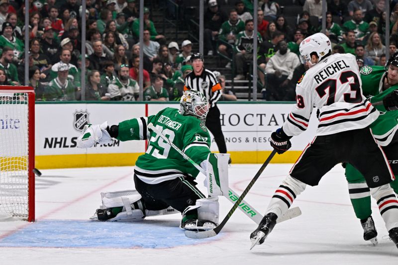 Nov 7, 2024; Dallas, Texas, USA; Chicago Blackhawks left wing Lukas Reichel (73) attempts to redirect the puck past Dallas Stars goaltender Jake Oettinger (29) during the third period at the American Airlines Center. Mandatory Credit: Jerome Miron-Imagn Images