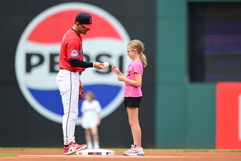 Aug 25, 2024; Cleveland, Ohio, USA; Cleveland Guardians second baseman Andres Gimenez (0) gives a ball to a young fan before the game between the Guardians and the Texas Rangers at Progressive Field. Mandatory Credit: Ken Blaze-USA TODAY Sports