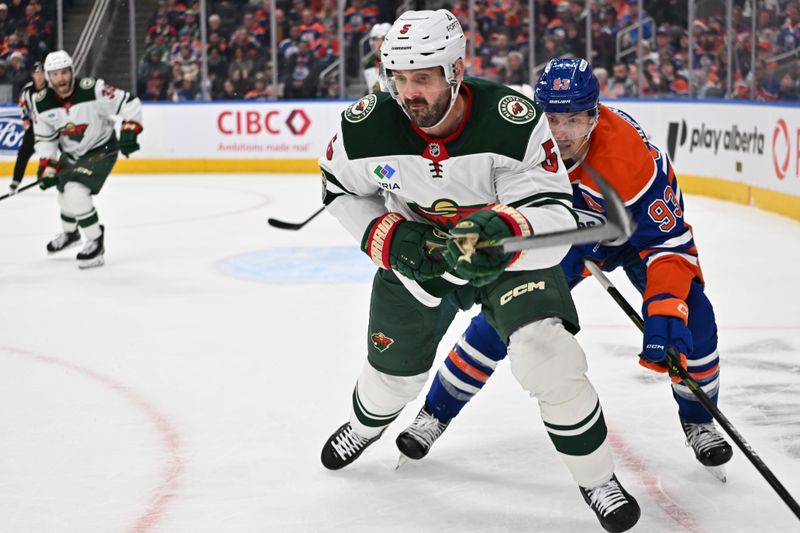 Dec 2, 2025; Edmonton, Alberta, CAN; Minnesota Wild defenseman  Jake Middleton (5) and Edmonton Oilers center Ryan Nugent-Hopkins (93) battle in front of Minnesota Wild goalie Jesper Wallstedt (30) during the third period at Rogers Place. Mandatory Credit: Walter Tychnowicz-Imagn Images