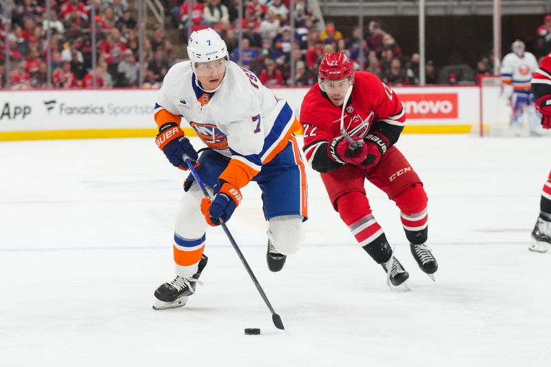 Oct 30, 2025; Raleigh, North Carolina, USA;  New York Islanders right wing Maxim Tsyplakov (7) skates with the puck past Carolina Hurricanes center Logan Stankoven (22) during the second period at Lenovo Center. Mandatory Credit: James Guillory-Imagn Images