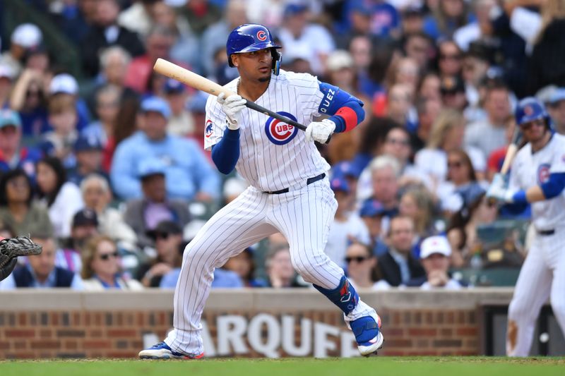Sep 29, 2024; Chicago, Illinois, USA; Chicago Cubs shortstop Luis Vazquez (12) bunts for his first MLB hit during the seventh inning against the Cincinnati Reds at Wrigley Field. Mandatory Credit: Patrick Gorski-Imagn Images