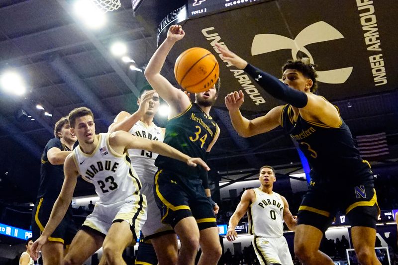 Dec 1, 2023; Evanston, Illinois, USA;Purdue Boilermakers forward Camden Heide (23) and Northwestern Wildcats center Matthew Nicholson (34) go for the ball during the first half at Welsh-Ryan Arena. Mandatory Credit: David Banks-USA TODAY Sports