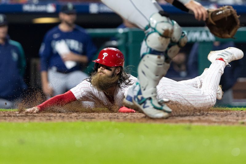 Apr 26, 2023; Philadelphia, Pennsylvania, USA; Philadelphia Phillies center fielder Brandon Marsh (16) slides into home plate past Seattle Mariners catcher Cal Raleigh (29) to score the go ahead run during the eighth inning at Citizens Bank Park. Mandatory Credit: Bill Streicher-USA TODAY Sports