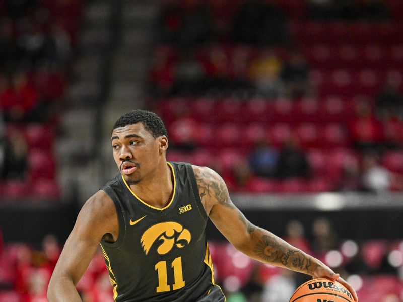 Feb 14, 2024; College Park, Maryland, USA;  Iowa Hawkeyes guard Tony Perkins (11) looks to pass at the top of the key during the fist half against the Maryland Terrapins at Xfinity Center. Mandatory Credit: Tommy Gilligan-USA TODAY Sports