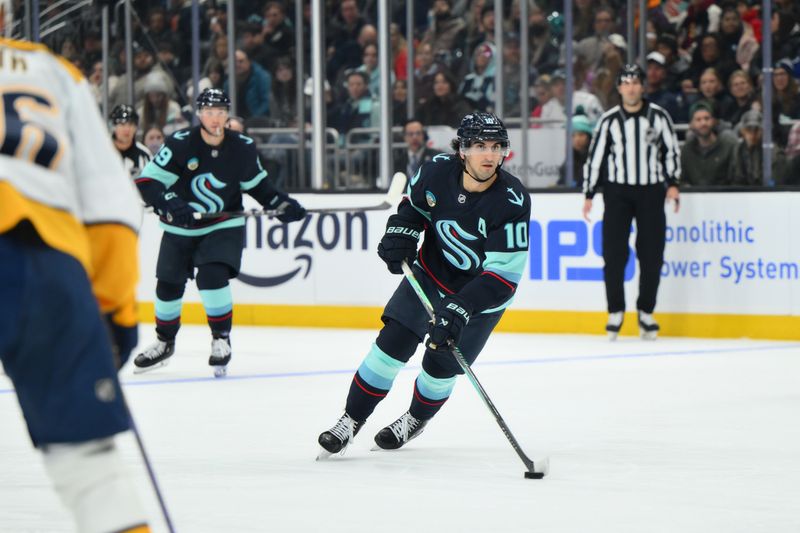 Jan 1, 2026; Seattle, Washington, USA; Seattle Kraken center Matty Beniers (10) plays the puck against the Nashville Predators during the second period at Climate Pledge Arena. Mandatory Credit: Steven Bisig-Imagn Images