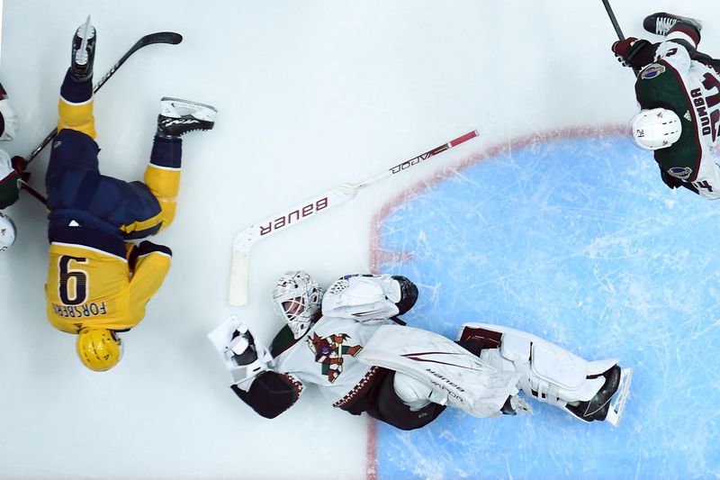 Feb 10, 2024; Nashville, Tennessee, USA; Arizona Coyotes goaltender Connor Ingram (39) falls in the crease after being hit by Nashville Predators left wing Filip Forsberg (9) on a play during the second period at Bridgestone Arena. Mandatory Credit: Christopher Hanewinckel-USA TODAY Sports