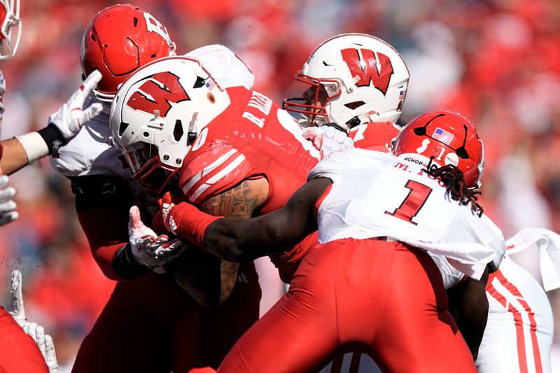 Oct 7, 2023; Madison, Wisconsin, USA;  Wisconsin Badgers running back Braelon Allen (0) is tackled with the football during the fourth quarter against the Rutgers Scarlet Knights at Camp Randall Stadium. Mandatory Credit: Jeff Hanisch-USA TODAY Sports