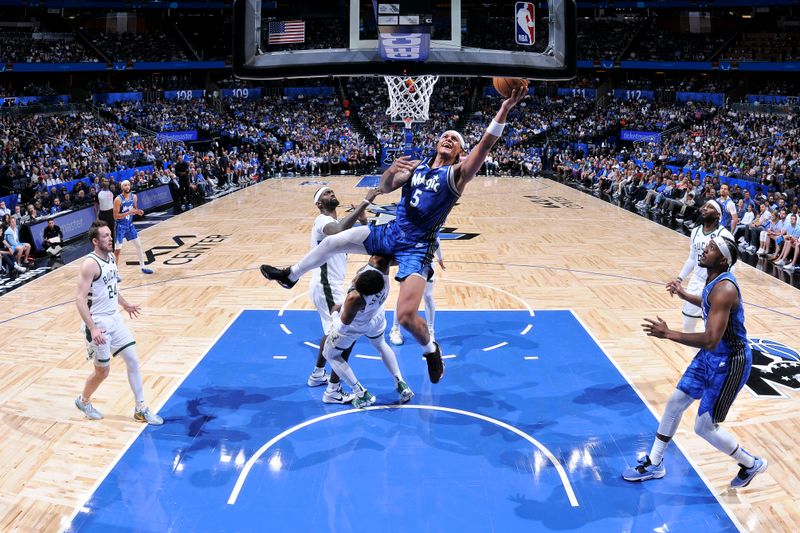 ORLANDO, FL - APRIL 14: Paolo Banchero #5 of the Orlando Magic drives to the basket during the game against the Milwaukee Bucks on April 14, 2024 at Kia Center in Orlando, Florida. NOTE TO USER: User expressly acknowledges and agrees that, by downloading and or using this photograph, User is consenting to the terms and conditions of the Getty Images License Agreement. Mandatory Copyright Notice: Copyright 2024 NBAE (Photo by Fernando Medina/NBAE via Getty Images)