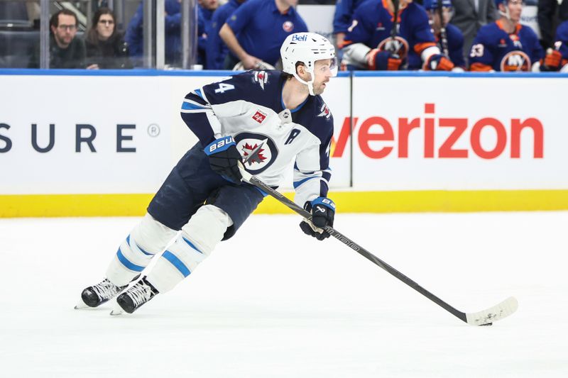 Mar 4, 2025; Elmont, New York, USA;  Winnipeg Jets defenseman Josh Morrissey (44) controls the puck in the second period against the New York Islanders at UBS Arena. Mandatory Credit: Wendell Cruz-Imagn Images