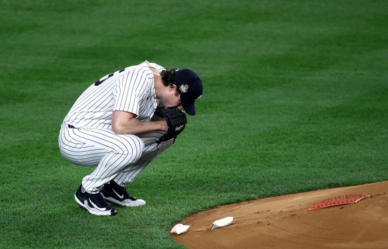 Oct 30, 2024; New York, New York, USA; New York Yankees pitcher Gerrit Cole (45) crouches before the first inning against the Los Angeles Dodgers in game five of the 2024 MLB World Series at Yankee Stadium. Mandatory Credit: Wendell Cruz-Imagn Images