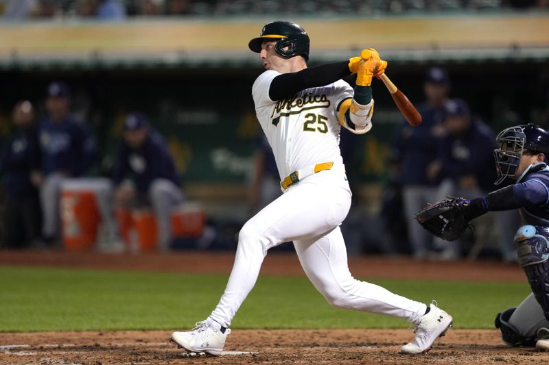 Aug 21, 2024; Oakland, California, USA; Oakland Athletics designated hitter Brent Rooker (25) hits an RBI single against the Tampa Bay Rays during the sixth inning at Oakland-Alameda County Coliseum. Mandatory Credit: Darren Yamashita-USA TODAY Sports