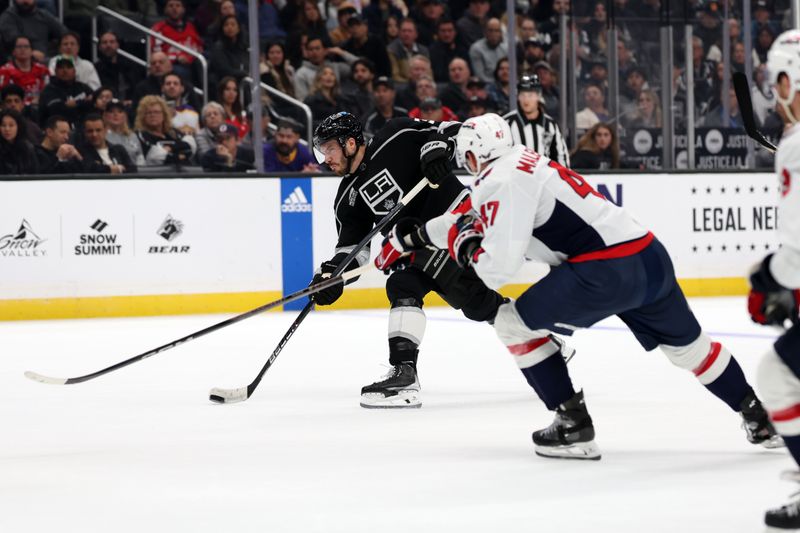 Nov 29, 2023; Los Angeles, California, USA; Los Angeles Kings defenseman Matt Roy (3) shoots the puck as  Washington Capitals left wing Beck Malenstyn (47) defends during the second period at Crypto.com Arena. Mandatory Credit: Kiyoshi Mio-USA TODAY Sports.