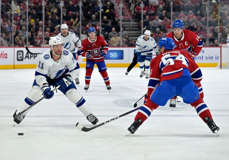 Nov 7, 2023; Montreal, Quebec, CAN; Tampa Bay Lightning forward Luke Glendening (11) plays the puck and Montreal Canadiens defenseman Jordan Harris (54) defends during the second period at the Bell Centre. Mandatory Credit: Eric Bolte-USA TODAY Sports