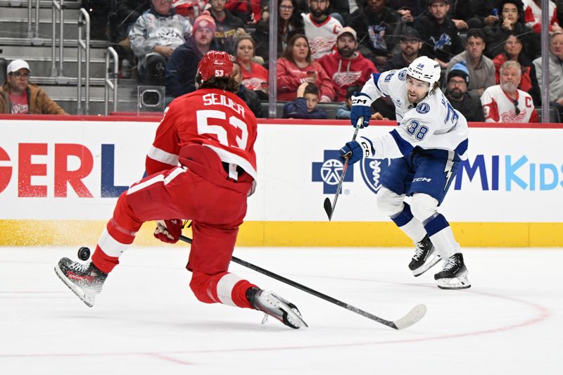 Nov 28, 2025; Detroit, Michigan, USA; Tampa Bay Lightning left wing Brandon Hagel (38) scores an empty net goal past Detroit Red Wings defenseman Moritz Seider (53) in the third period at Little Caesars Arena. Mandatory Credit: Lon Horwedel-Imagn Images