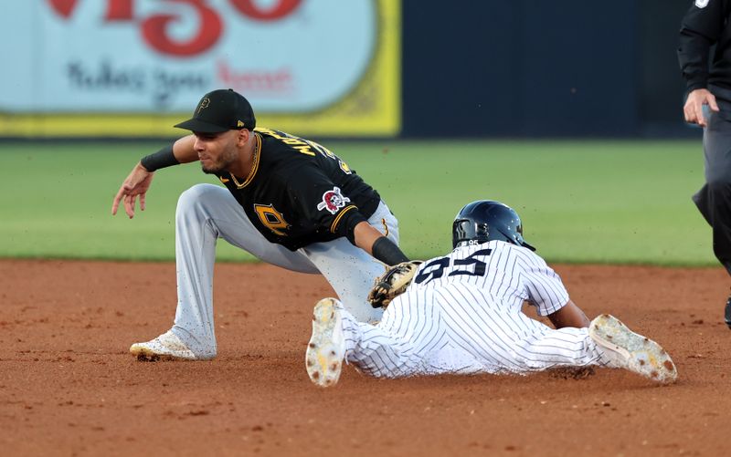 Mar 16, 2023; Tampa, Florida, USA;  Pittsburgh Pirates left fielder Tucupita Marcano (30) tags out New York Yankees infielder Oswaldo Cabrera (95) as he attempts to steal during the second inning at George M. Steinbrenner Field. Mandatory Credit: Kim Klement-USA TODAY Sports