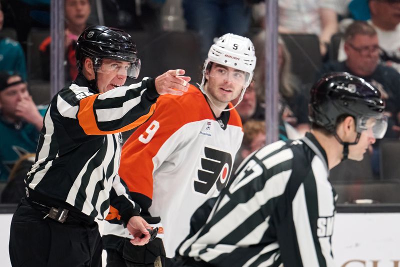 Mar 21, 2026; San Jose, California, USA; Referee Brian Pochmara (16) gestures toward the San Jose Sharks penalty box as Philadelphia Flyers defenseman Jamie Drysdale (9) looks on during the third period at SAP Center at San Jose. Mandatory Credit: Robert Edwards-Imagn Images