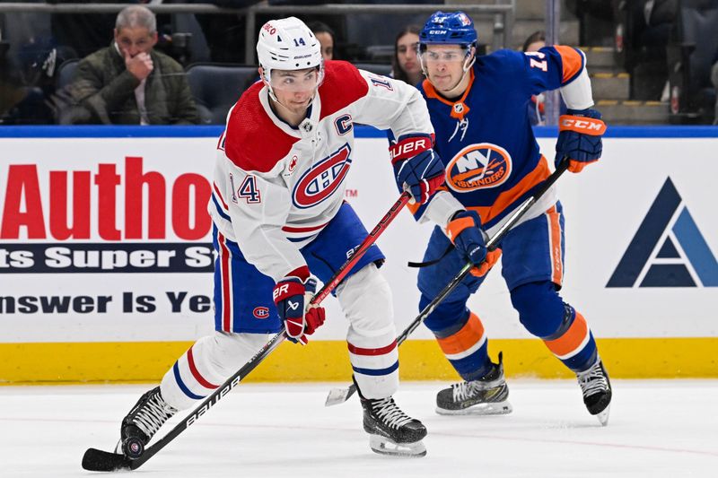 Apr 11, 2024; Elmont, New York, USA; Montreal Canadiens center Nick Suzuki (14) attempts a pass against the New York Islanders during the first period at UBS Arena. Mandatory Credit: Dennis Schneidler-USA TODAY Sports