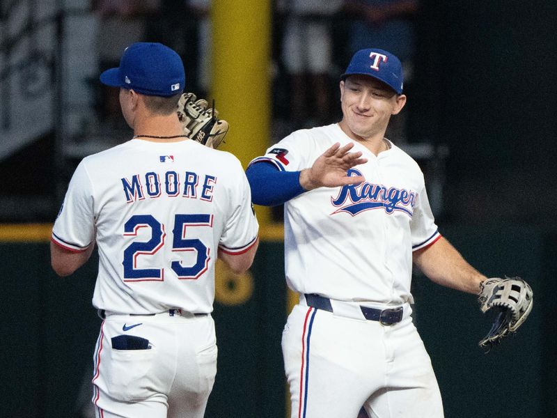 Sep 10, 2025; Arlington, Texas, USA; Texas Rangers left fielder Wyatt Langford (36) and second baseman Dylan Moore (25) celebrate their teamís 6-3 win over the Milwaukee Brewers following the inning at Globe Life Field. Mandatory Credit: Jim Cowsert-Imagn Images
