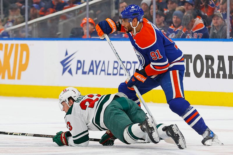 Dec 8, 2023; Edmonton, Alberta, CAN; Edmonton Oilers forward Evander Kane (91) trips up Minnesota Wild forward Marco Rossi (23) during the first period at Rogers Place. Mandatory Credit: Perry Nelson-USA TODAY Sports