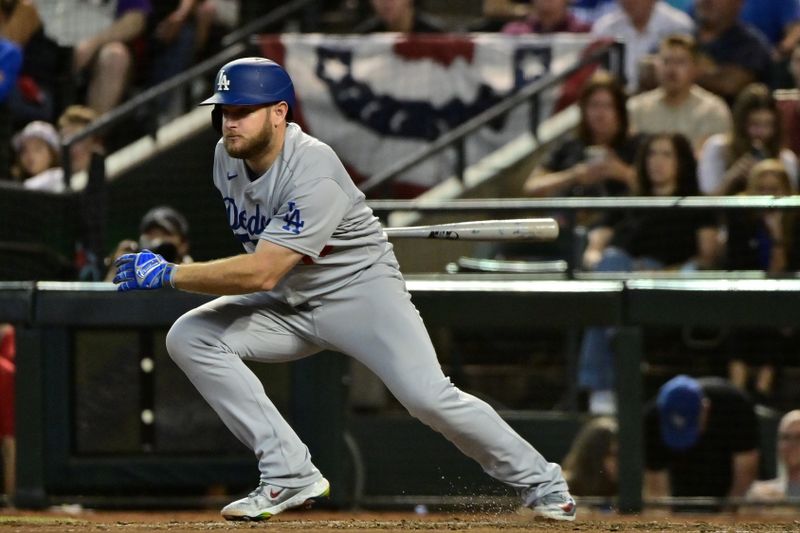 Oct 11, 2023; Phoenix, Arizona, USA; Los Angeles Dodgers third baseman Max Muncy (13) hits a single against the Arizona Diamondbacks in the seventh inning for game three of the NLDS for the 2023 MLB playoffs at Chase Field. Mandatory Credit: Matt Kartozian-USA TODAY Sports