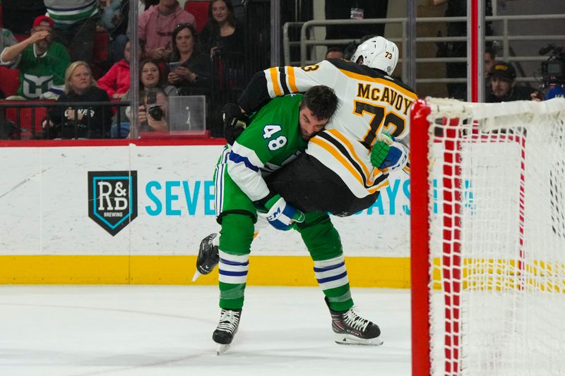 Mar 26, 2023; Raleigh, North Carolina, USA;  Carolina Hurricanes left wing Jordan Martinook (48) and Boston Bruins defenseman Charlie McAvoy (73) fight during the first period at PNC Arena. Mandatory Credit: James Guillory-USA TODAY Sports