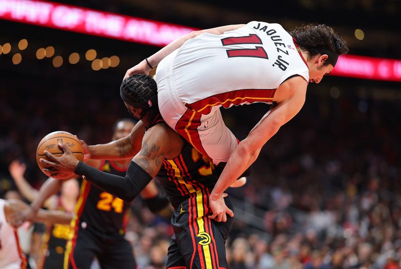 ATLANTA, GEORGIA - APRIL 09:  Jaime Jaquez Jr. #11 of the Miami Heat fouls Wesley Matthews #32 of the Atlanta Hawks as he falls over top of him during the fourth quarter at State Farm Arena on April 09, 2024 in Atlanta, Georgia.  NOTE TO USER: User expressly acknowledges and agrees that, by downloading and/or using this photograph, user is consenting to the terms and conditions of the Getty Images License Agreement.  (Photo by Kevin C. Cox/Getty Images)