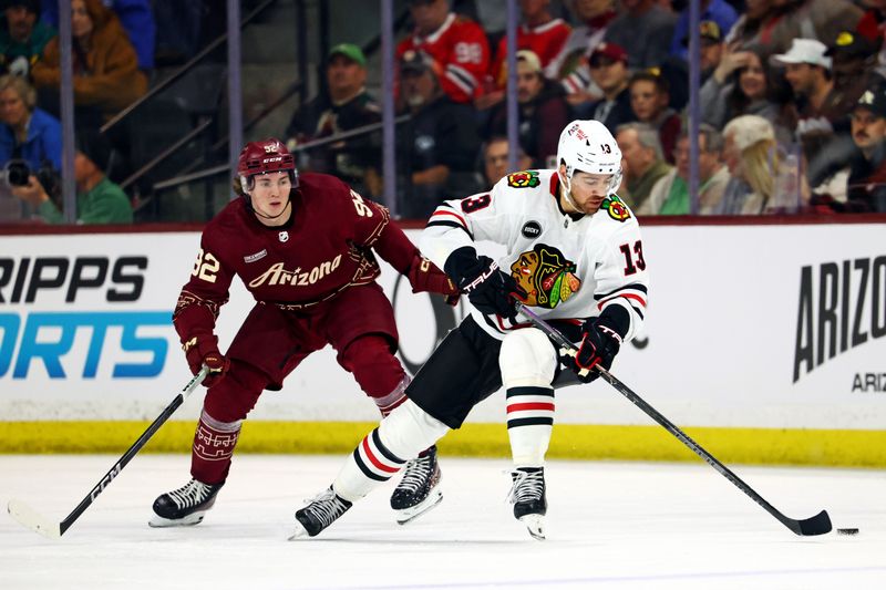 Mar 5, 2024; Tempe, Arizona, USA;  Chicago Blackhawks left wing Zach Sanford (13) controls the puck against Arizona Coyotes defenseman Vladislav Kolyachonok (52) during the second period at Mullett Arena. Mandatory Credit: Mark J. Rebilas-USA TODAY Sports