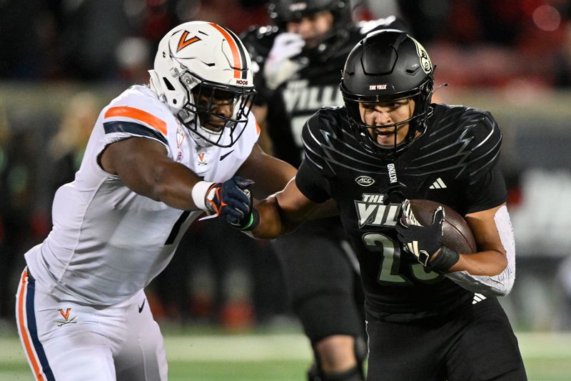 Nov 9, 2023; Louisville, Kentucky, USA; Louisville Cardinals running back Isaac Guerendo (23) runs the ball against Virginia Cavaliers defensive end Paul Akere (1) during the first half at L&N Federal Credit Union Stadium. Mandatory Credit: Jamie Rhodes-USA TODAY Sports