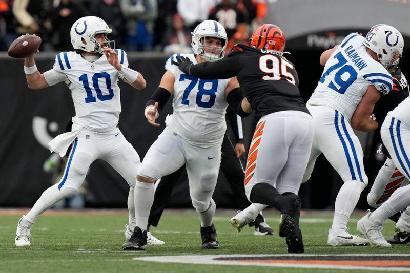 Indianapolis Colts quarterback Gardner Minshew (10) throws as teammates center Ryan Kelly (78) and offensive tackle Bernhard Raimann (79) hold off Cincinnati Bengals defensive tackle Zach Carter (95) during the first half of an NFL football game in Cincinnati, Sunday, Dec. 10, 2023. (AP Photo/Carolyn Kaster)