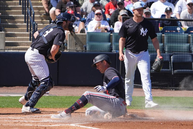 Mar 6, 2025; Tampa, Florida, USA; Minnesota Twins shortstop Brooks Lee (2) slides into home as New York Yankees catcher Austin Wells (28) tries to make the tag as pitcher Gerrit Cole (45) looks on during the second inning at George M. Steinbrenner Field. Mandatory Credit: Dave Nelson-Imagn Images