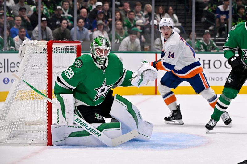 Nov 18, 2025; Dallas, Texas, USA; Dallas Stars goaltender Jake Oettinger (29) and New York Islanders center Bo Horvat (14) look for the puck during the first period at the American Airlines Center. Mandatory Credit: Jerome Miron-Imagn Images