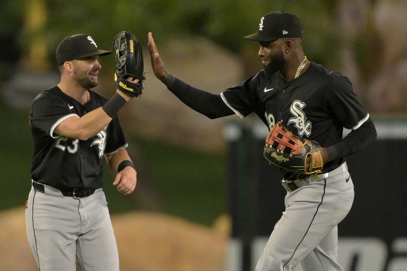 Sep 16, 2024; Anaheim, California, USA; Chicago White Sox left fielder Andrew Benintendi (23) and Chicago White Sox center fielder Luis Robert Jr. (88) high five after the final out of the ninth inning defeating the Los Angeles Angels at Angel Stadium. Mandatory Credit: Jayne Kamin-Oncea-Imagn Images