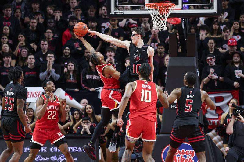 Feb 25, 2024; Piscataway, New Jersey, USA; Rutgers Scarlet Knights guard Gavin Griffiths (10) blocks a shot by Maryland Terrapins guard Jahmir Young (1) during the second half at Jersey Mike's Arena. Mandatory Credit: Vincent Carchietta-USA TODAY Sports