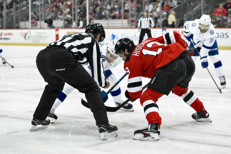 Feb 25, 2024; Newark, New Jersey, USA; Tampa Bay Lightning center Brayden Point (21) faces off against New Jersey Devils center Nico Hischier (13) during the first period at Prudential Center. Mandatory Credit: John Jones-USA TODAY Sports