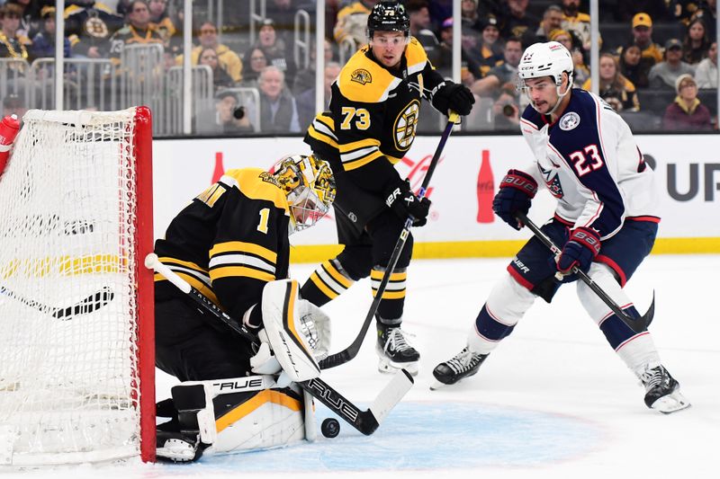 Nov 18, 2024; Boston, Massachusetts, USA;  Boston Bruins goaltender Jeremy Swayman (1) makes a save in front of Columbus Blue Jackets center Sean Monahan (23) during the second period at TD Garden. Mandatory Credit: Bob DeChiara-Imagn Images