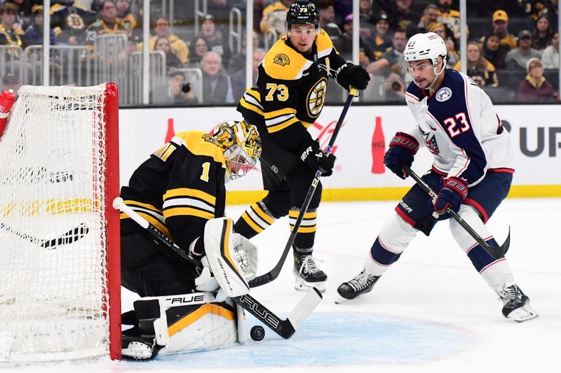 Nov 18, 2024; Boston, Massachusetts, USA;  Boston Bruins goaltender Jeremy Swayman (1) makes a save in front of Columbus Blue Jackets center Sean Monahan (23) during the second period at TD Garden. Mandatory Credit: Bob DeChiara-Imagn Images