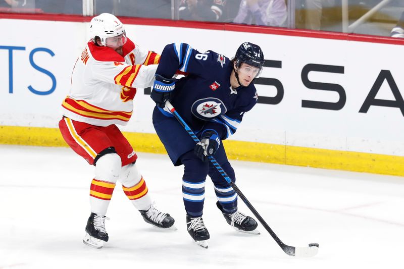 Apr 4, 2024; Winnipeg, Manitoba, CAN; Winnipeg Jets center Morgan Barron (36) is checked by Calgary Flames defenseman Rasmus Andersson (4) in the third period at Canada Life Centre. Mandatory Credit: James Carey Lauder-USA TODAY Sports