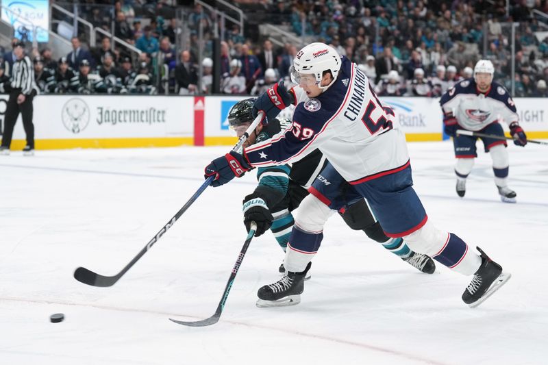 Feb 17, 2024; San Jose, California, USA; Columbus Blue Jackets right wing Yegor Chinakhov (59) shoots against San Jose Sharks center Ryan Carpenter (back) during the first period at SAP Center at San Jose. Mandatory Credit: Darren Yamashita-USA TODAY Sports