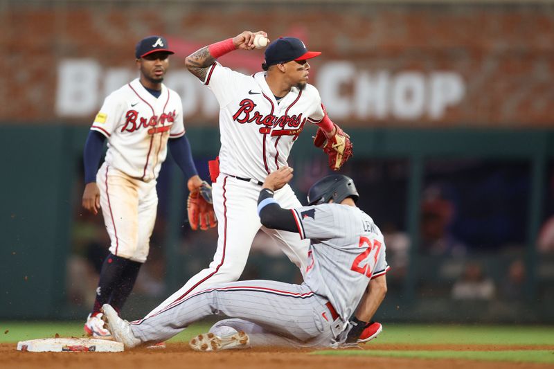 Jun 27, 2023; Atlanta, Georgia, USA; Atlanta Braves shortstop Orlando Arcia (11) turns a double play over Minnesota Twins third baseman Royce Lewis (23) in the sixth inning at Truist Park. Mandatory Credit: Brett Davis-USA TODAY Sports
